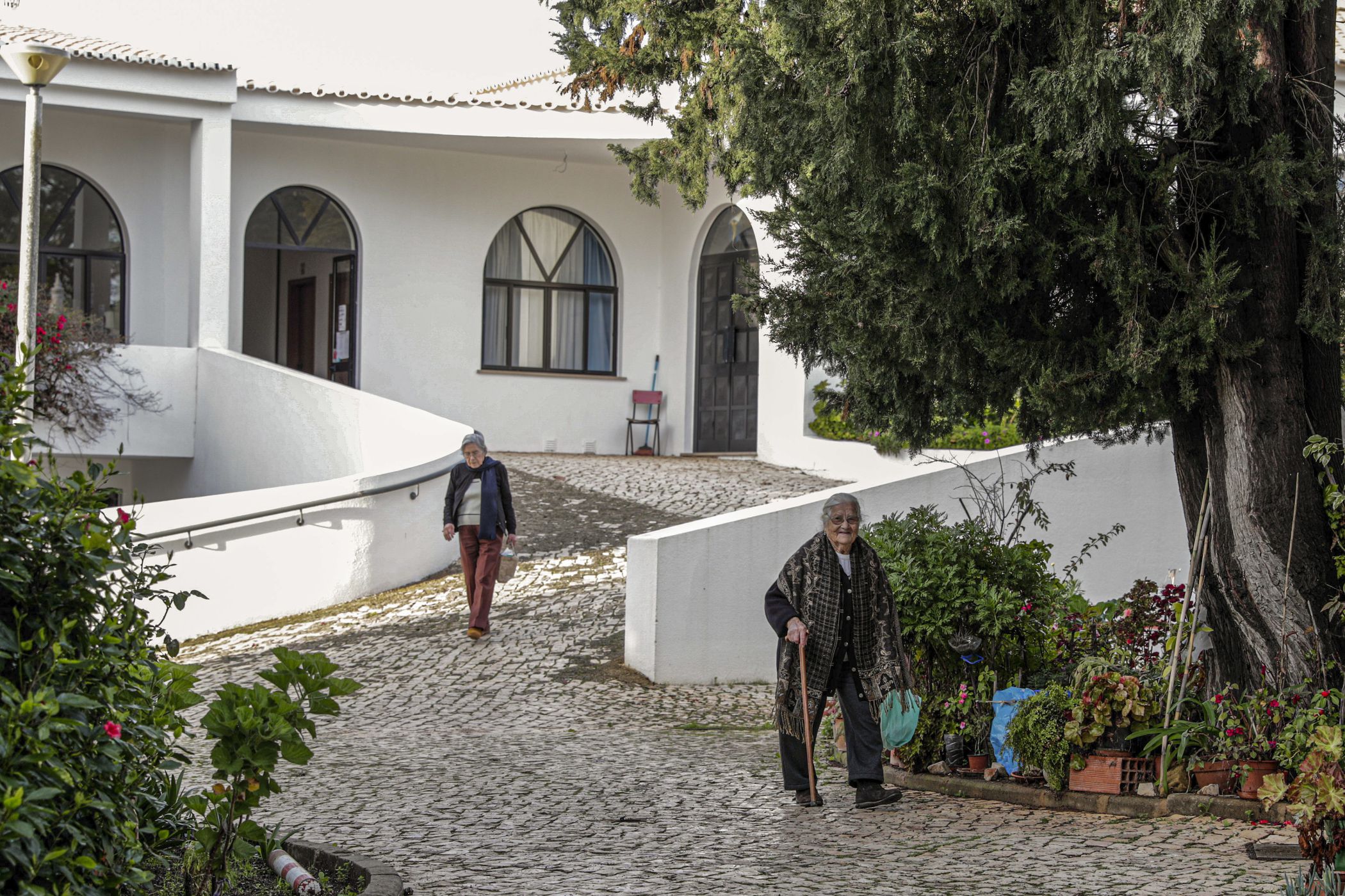 Moradores na Aldeia de São José de Alcalar, um lar em que os idosos vivem de forma autónoma em 52 residências, em Portimão. Construída em 1990, a aldeia social, com uma população de 115 habitantes, foi edificada na freguesia da Mexilhoeira Grande, nos arredores de Portimão, sendo composta por 52 apartamentos de tipologia T1, T2 e T3, com vários serviços de apoio, entre os quais lavandaria, refeitório, salas de convívio, serviços médicos e de enfermagem e espaços ajardinados.